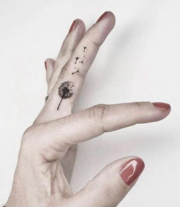 Minimalist dandelion finger tattoo