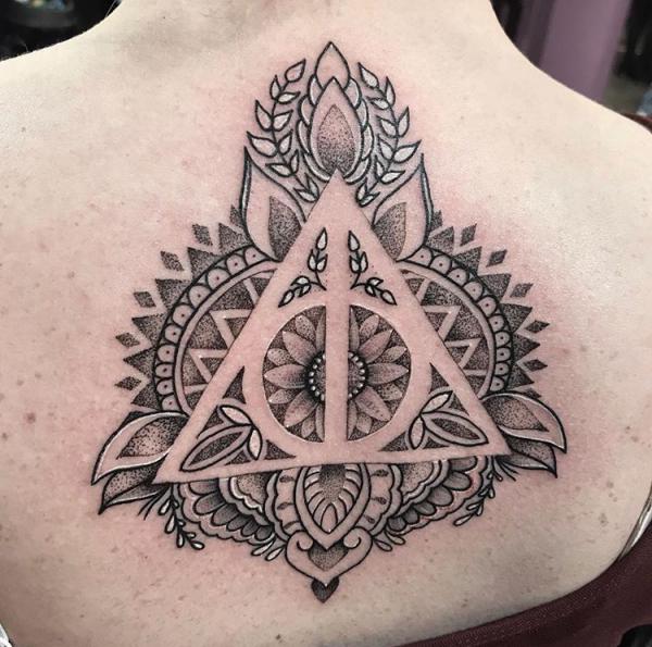 Dotwork and negative space mandala and deathly hallows tattoo