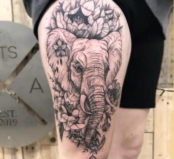 Elephant with flowers thigh tattoo