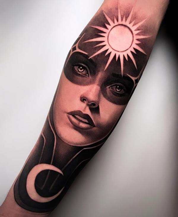 Female with moon and sun forearm tattoo