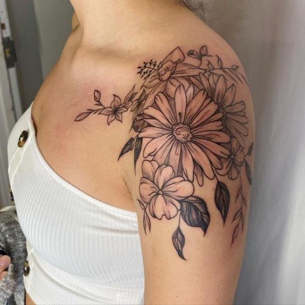 Fine line daisy shoulder tattoo