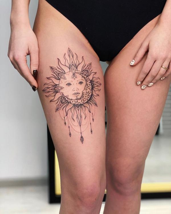 Floral sun and moon face thigh tattoo