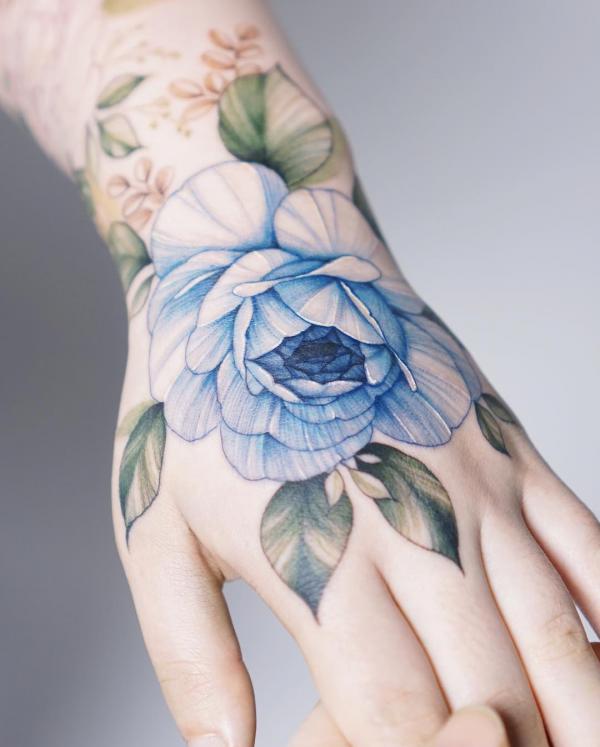 Light blue rose hand tattoo