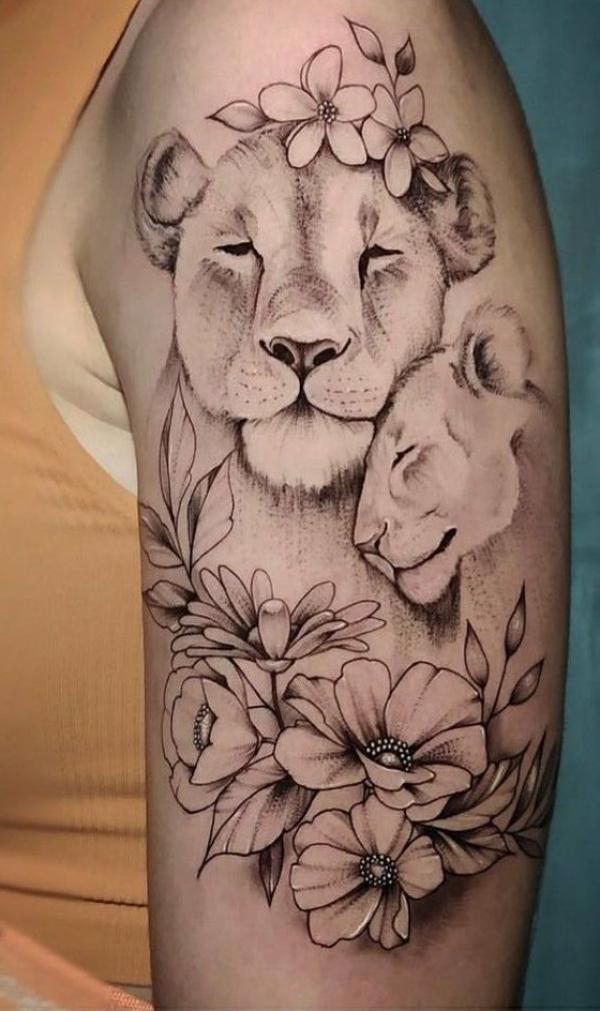 Lioness and cub with flowers upper arm tattoo