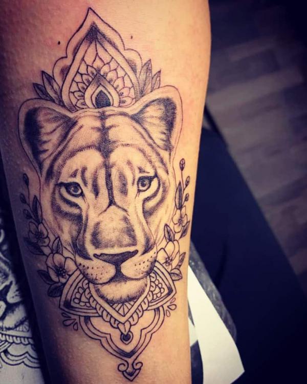 Lioness on mandala background tattoo