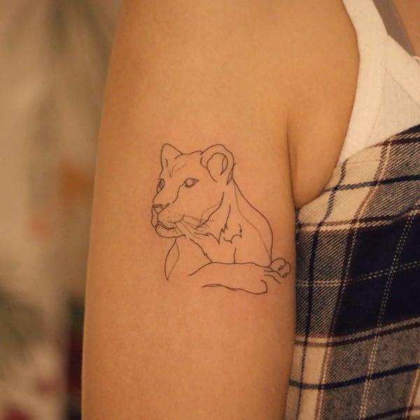 Lioness outline upper arm tattoo