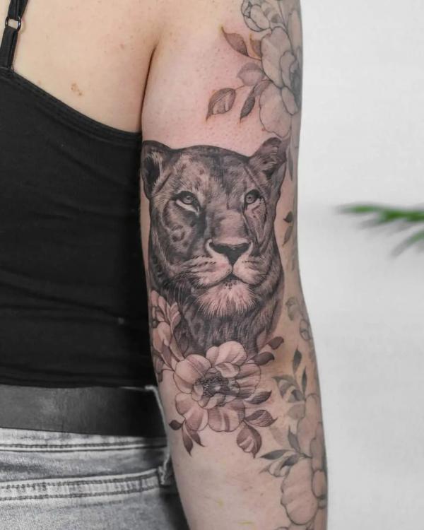 Lioness with flower back of arm tattoo