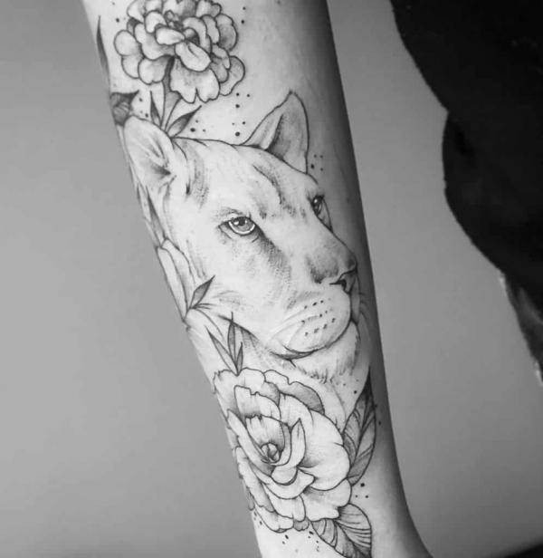 Lioness with flowers forearm tattoo