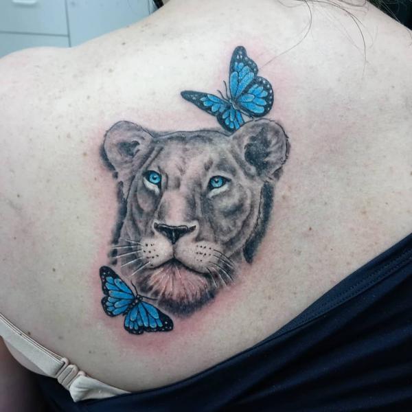 Lioness with two blue butterfies tattoo