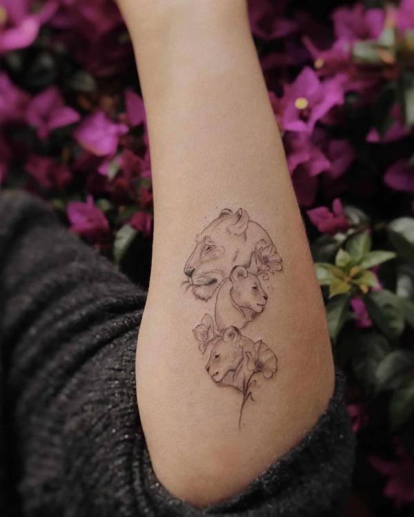 Lioness with two cubs outer forearm tattoo