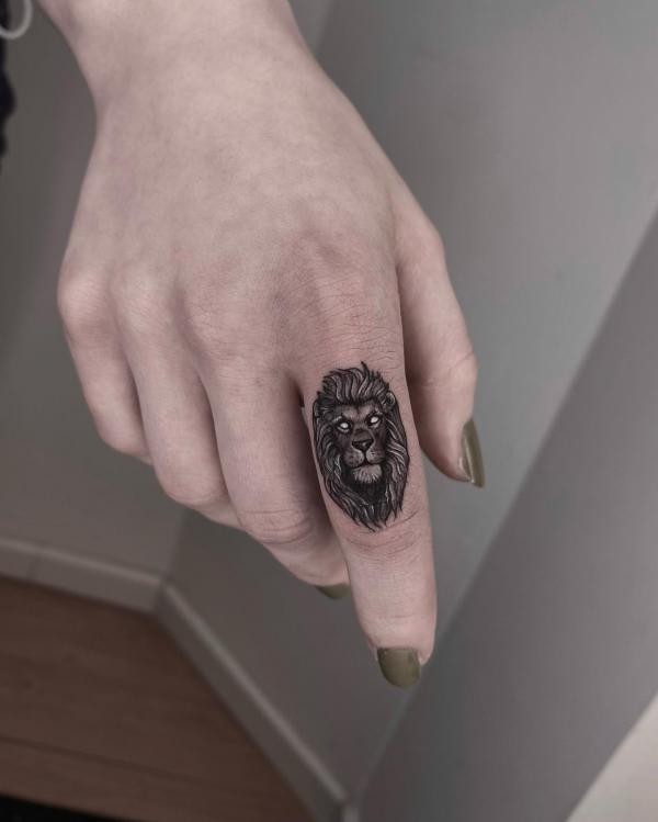 Male lion index finger tattoo