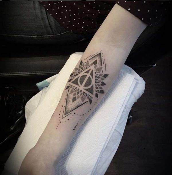 Mandala and deathly hallows tattoo on forearm