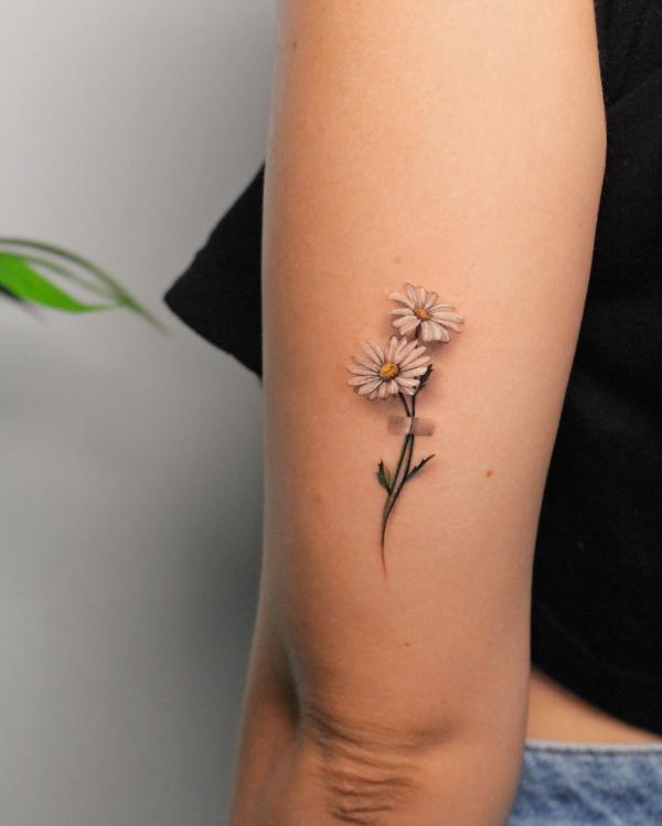 Minimalist daisy tattoo
