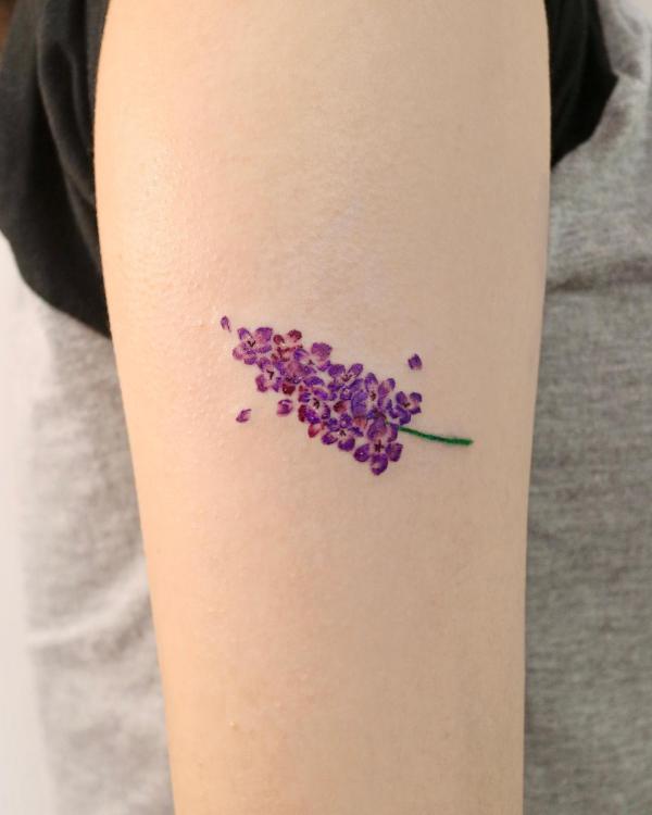 Minimalist lavender tattoo on upper arm