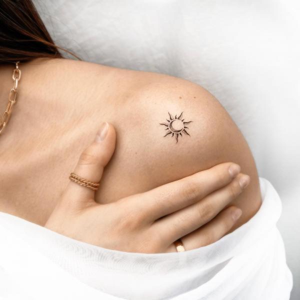 Minimalist sun and moon tattoo on shoulder