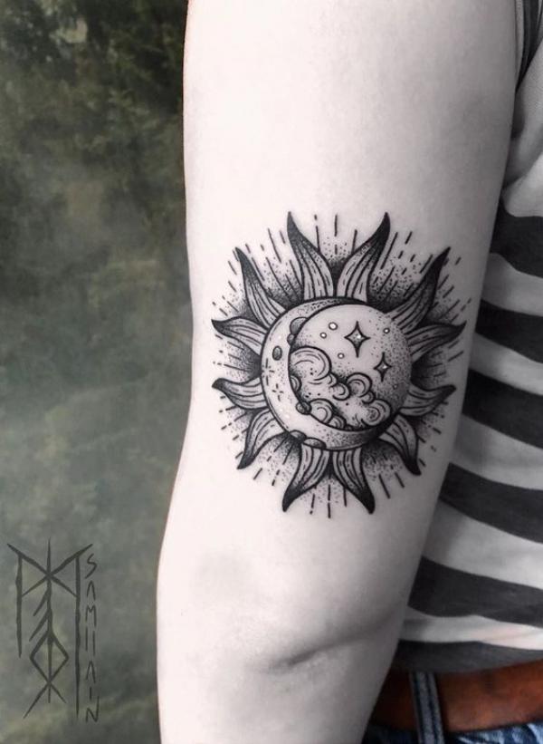 Moon in sun tattoo above elbow