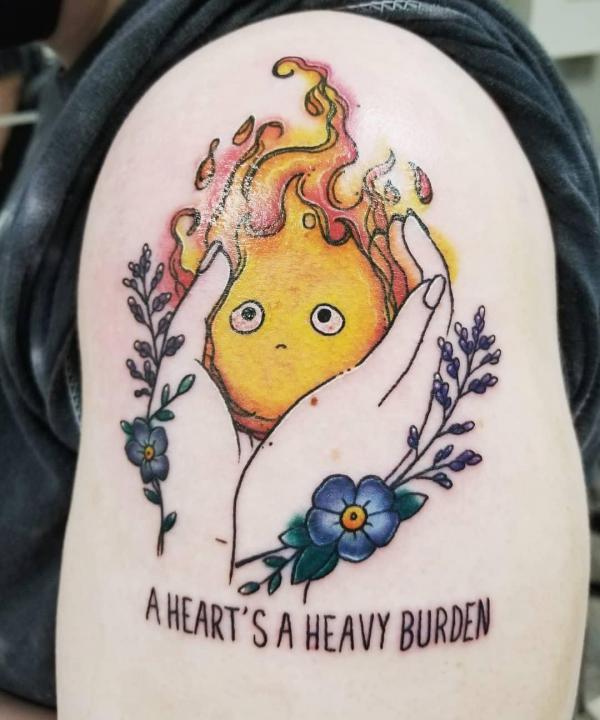 Negative space hands holding Calcifer tattoo with quote A heart is heavy burden