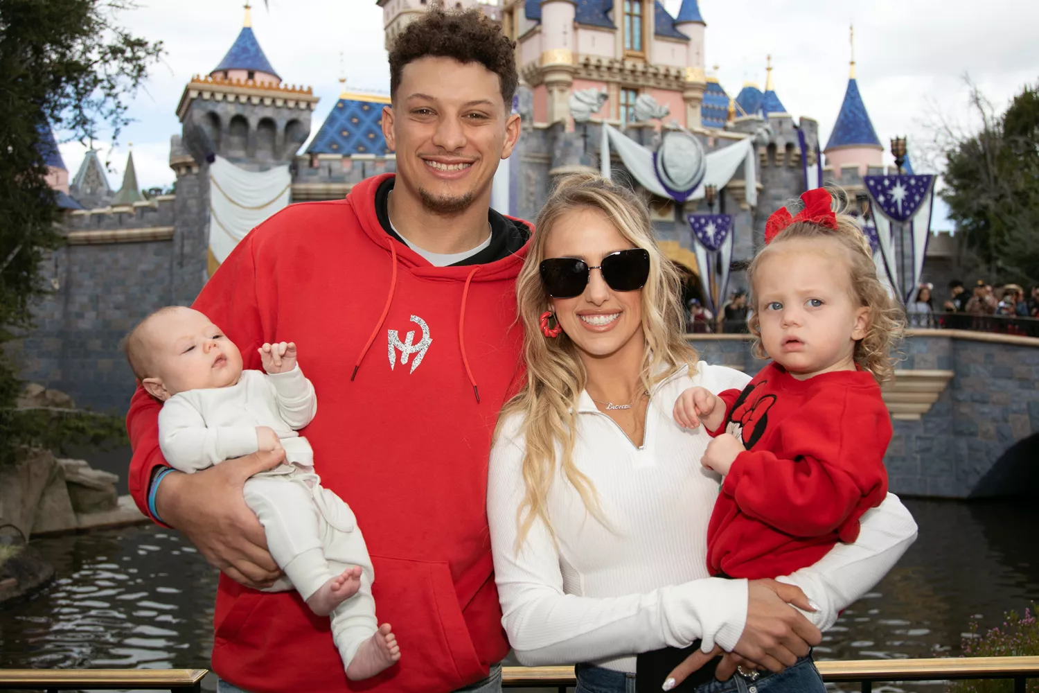 Patrick Mahomes of the Kansas City Chiefs and Brittney Mahomes pose with their 𝘤𝘩𝘪𝘭𝘥ren, Sterling, 1, and Bronze, 11 weeks old