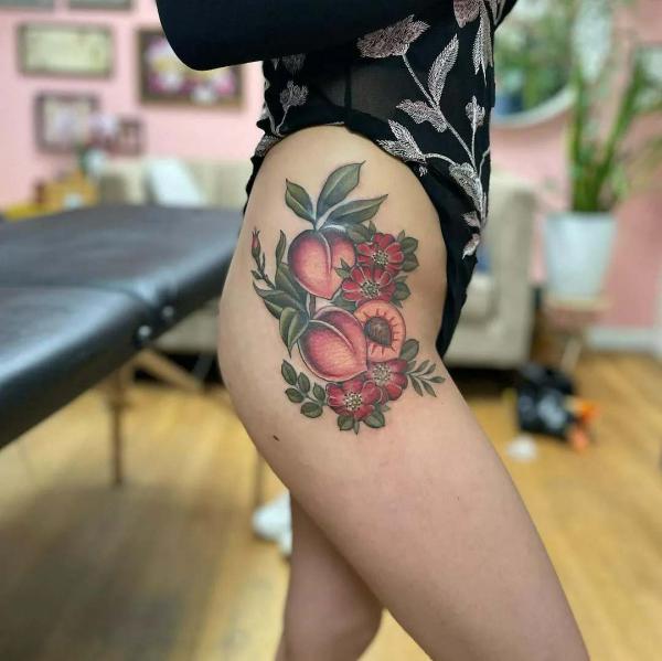 Peach with flowers tattoo on the side of hip