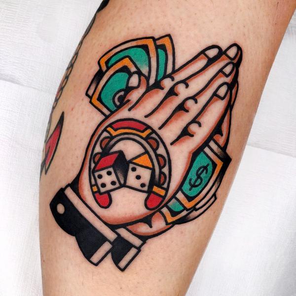 Praying hands with money and horseshoe and dices tattoo