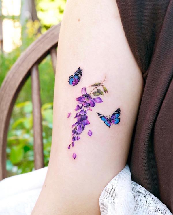 Purple wisteria and blue butterflies tgattoo on upper arm
