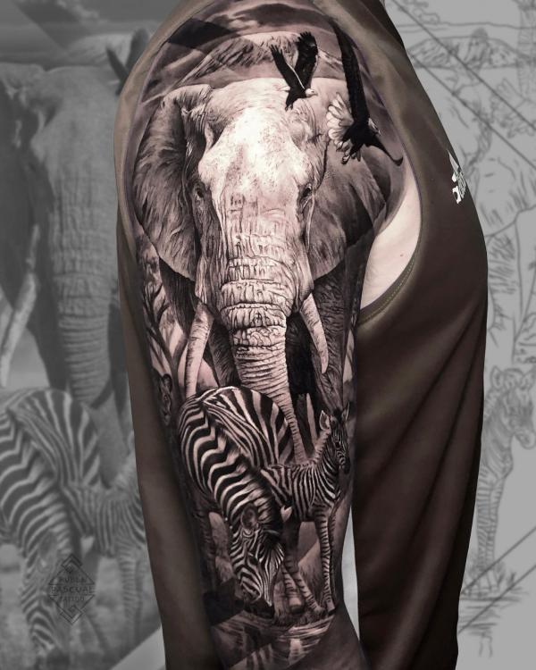 Realistic elephant and zebra sleeve tattoo on upper arm