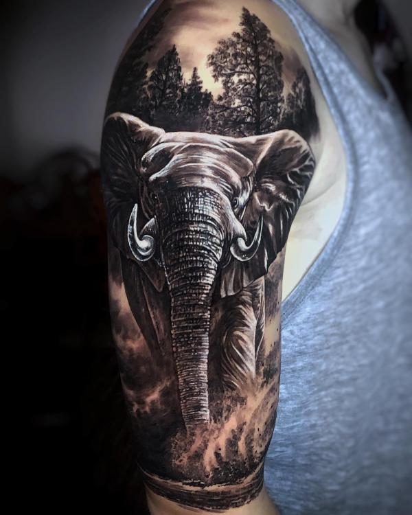Realistic elephant in forest sleeve tattoo