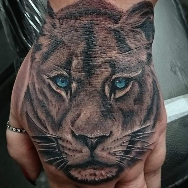 Realistic lioness hand tattoo