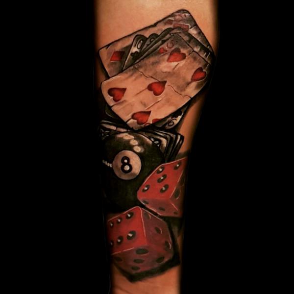 Red dices and cards tattoo forearm
