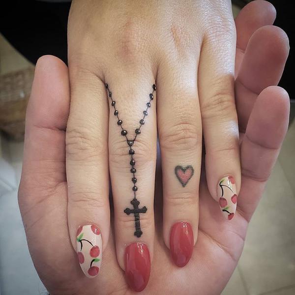 Rosary with cross tattoo on finger
