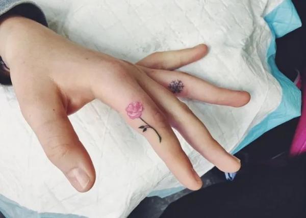 Rose and snowflake finger tattoo