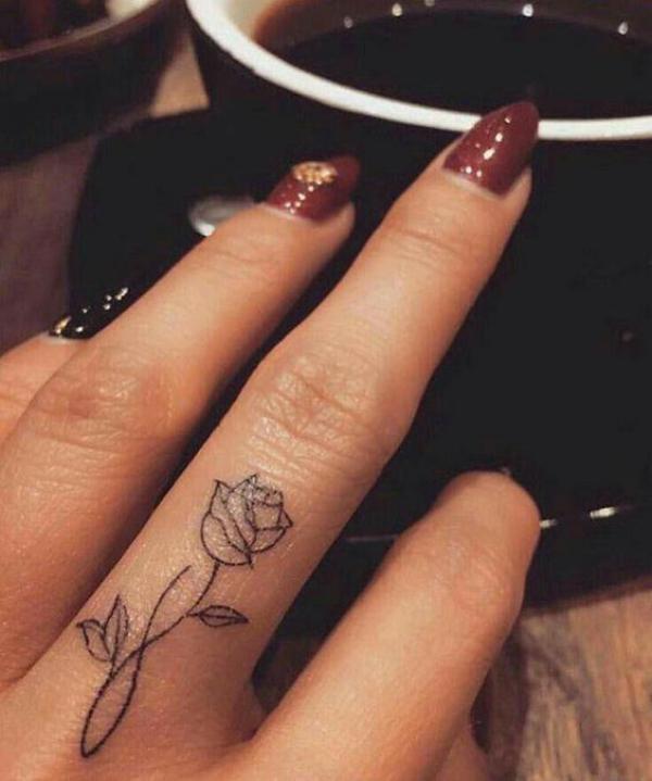 Rose outline middle finger tattoo