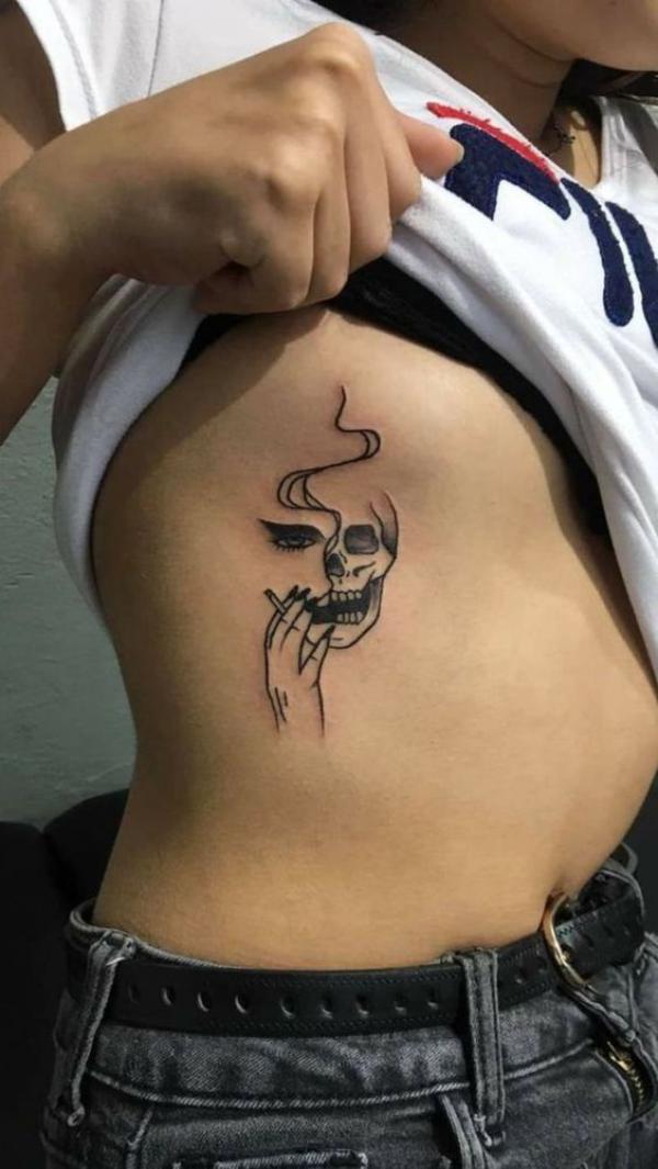 Simple skull smoking side boob tattoo