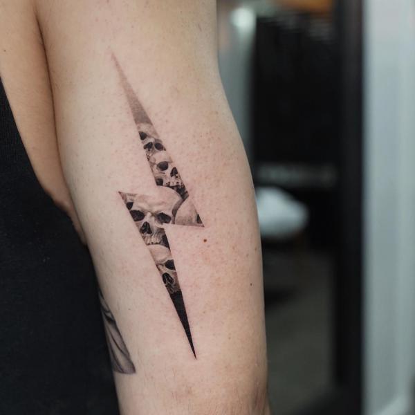 Skull lightning bolt arm tattoo