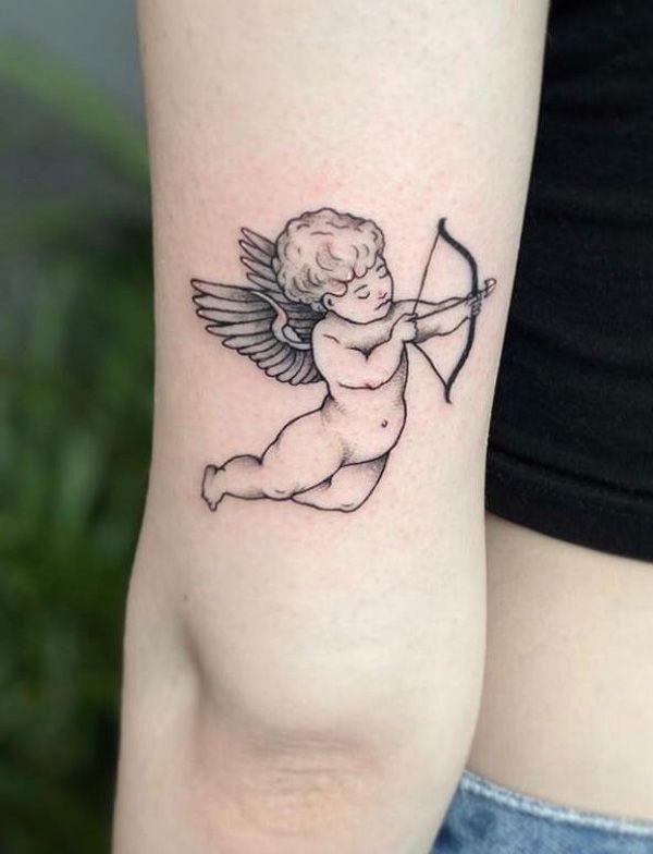 Small cupid tattoo above elbow