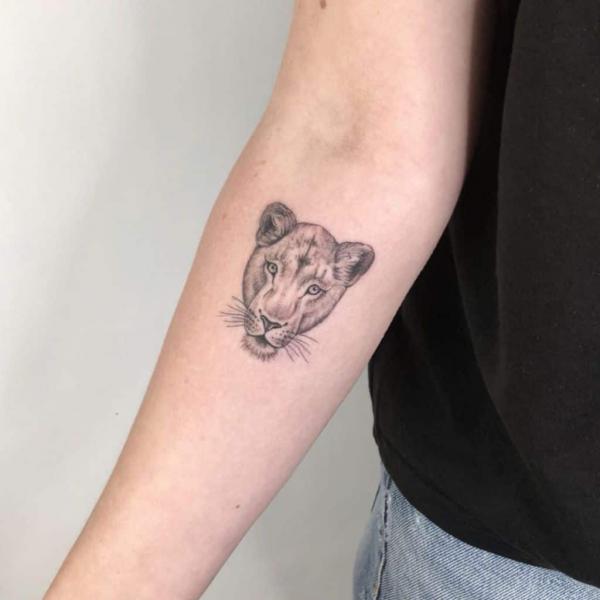 Small lioness head tattoo below inner elbow