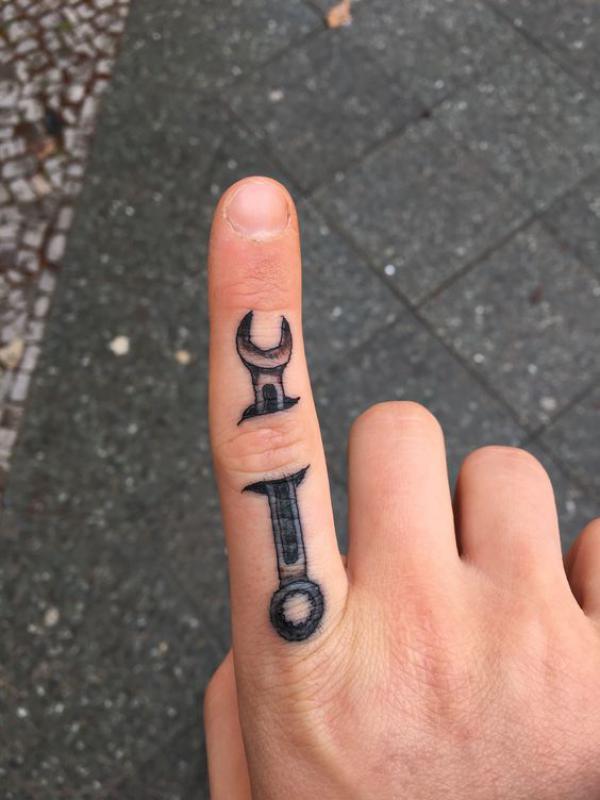 Small mechanical wrench finger tattoo