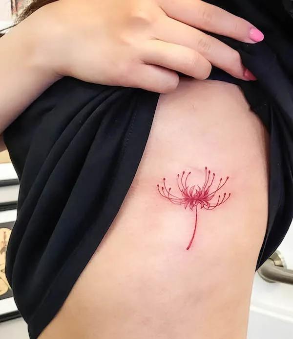 Small spider lily side boob tattoo