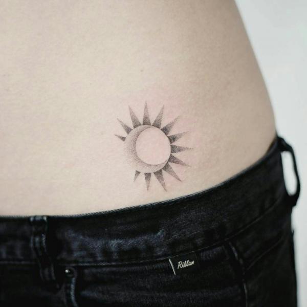 Small sun and moon tattoo on low back