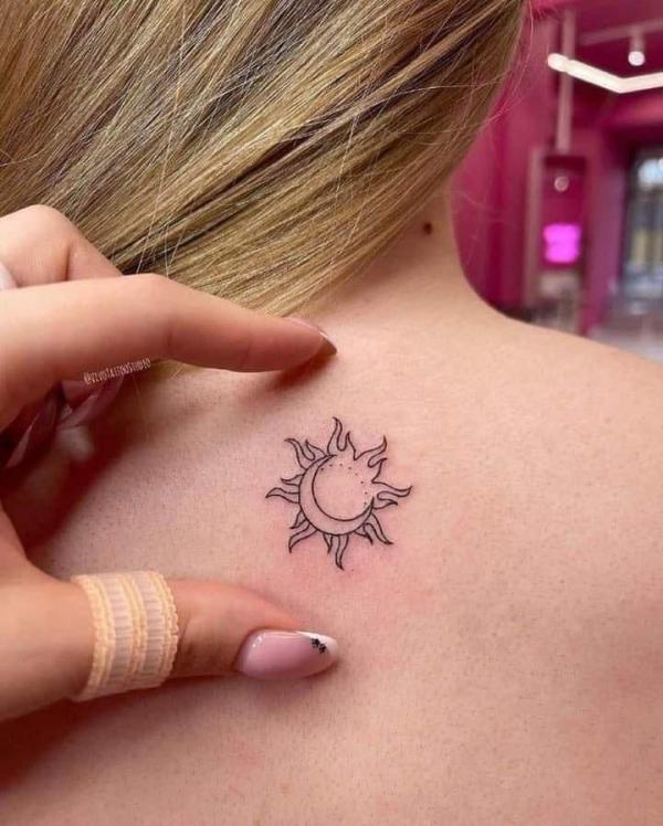 Small sun and moon tattoo on upper back