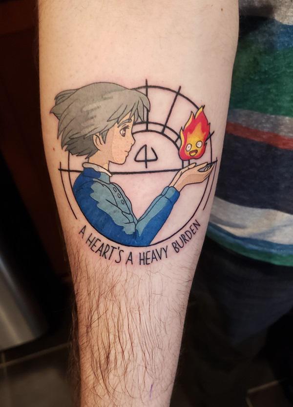 Sophie holding Calcifer tattoo with quote A heart is heavy burden