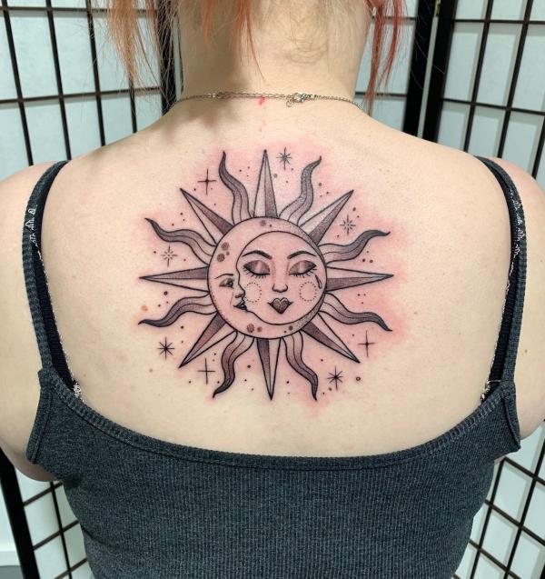 Sun and moon face back tattoo
