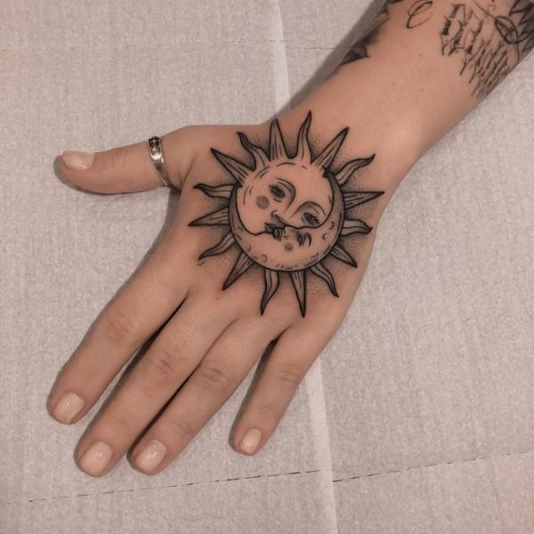 Sun and moon face hand tattoo
