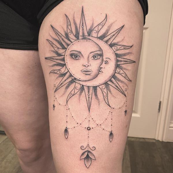 Sun and moon faces thigh tattoo