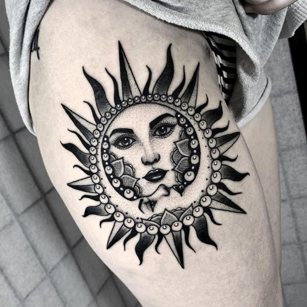 Sun and moon female face thigh tattoo
