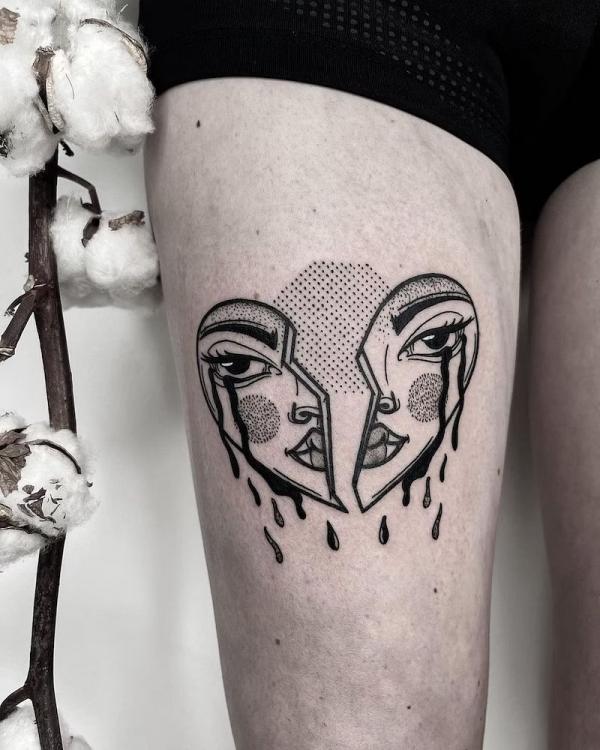 Tearful broken heart face tattoo on thigh