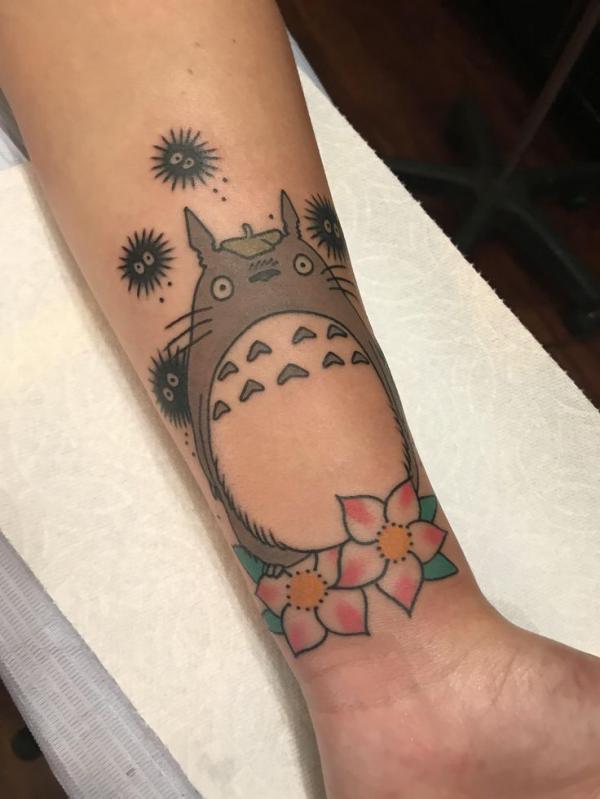 Totoro and Susuwatari with flower tattoo on forearm