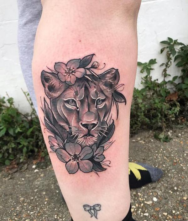 Traditional lioness with flower leg tattoo