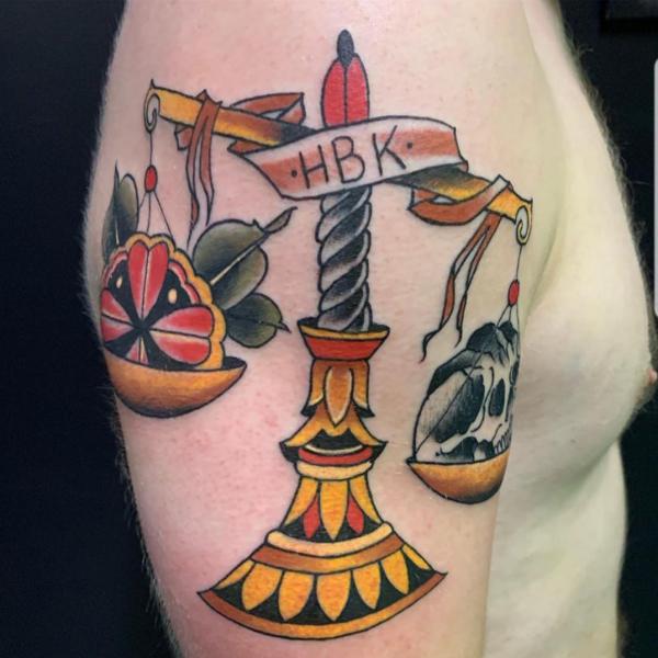 Traditional scales of justice tattoo on upper arm