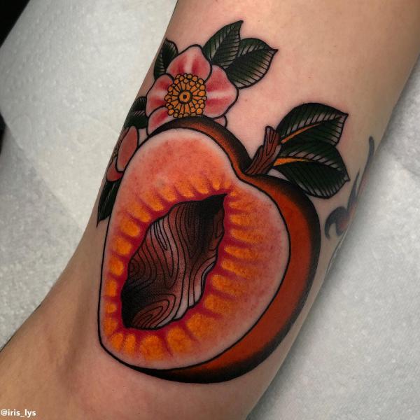 Traditional sliced peach with flower tattoo